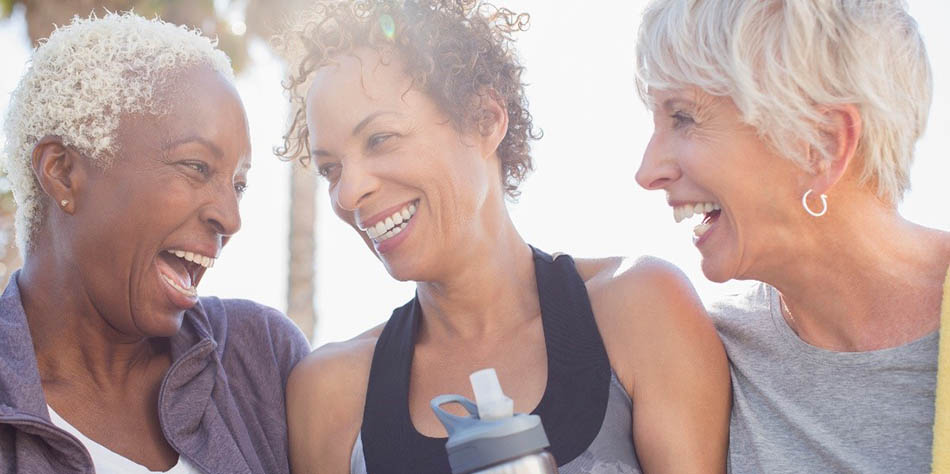 Three female seniors laugh together.